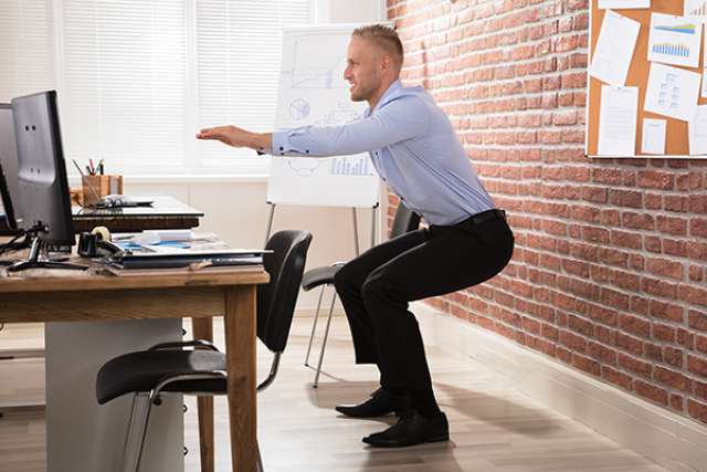 man doing squats in office